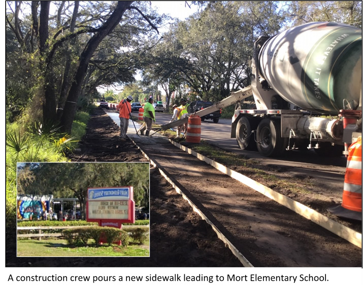 construction crew pours a new sidewalk leading to Mort Elementary School 